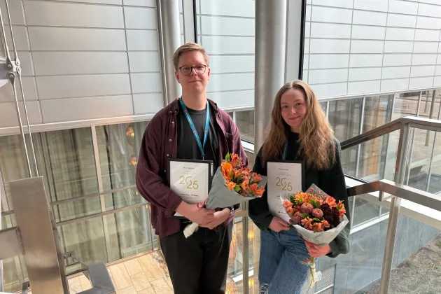 Michelle och Max poserar med diplom och blommor.